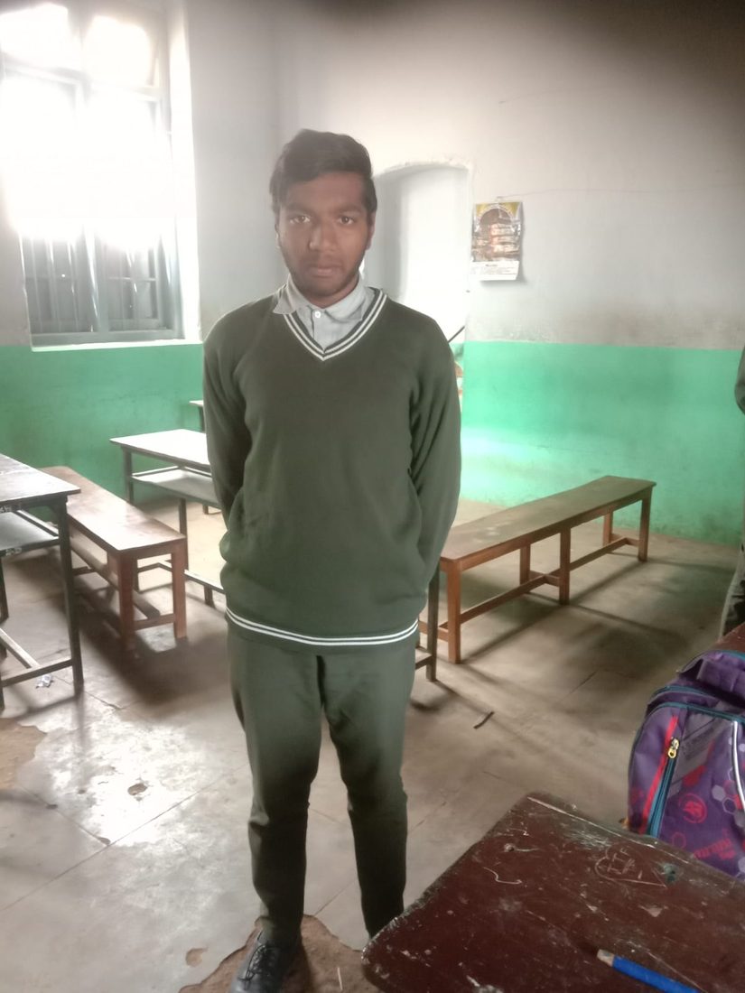 A student in his new school uniform, back in class for the term.