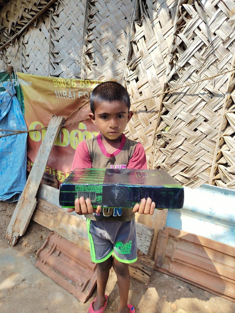 A boy with his new school shoes at home.