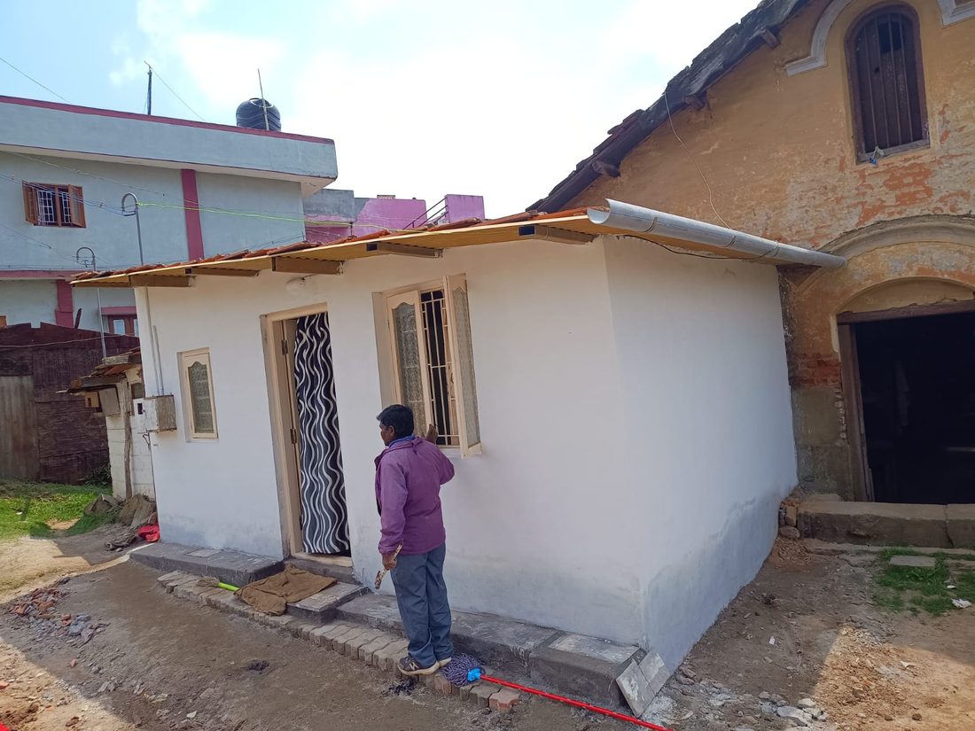 After — plastered walls, tiled roof and a gutter, built with local labour.